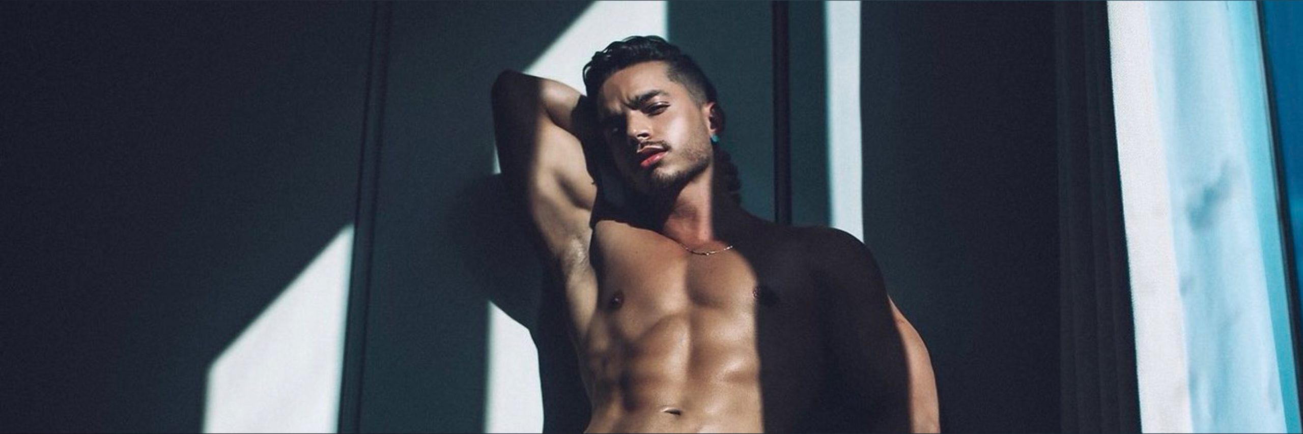 Handsome man posing shirtless in moody lighting — Best Male OnlyFans creator