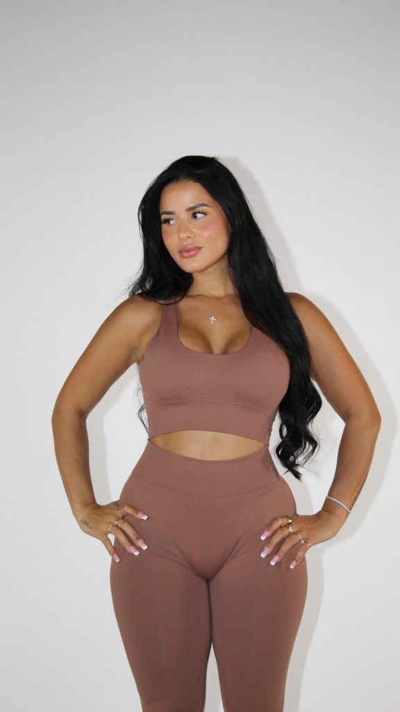 Katya Elise Henry standing against a white backdrop in a dusty rose activewear crop top and high-waisted leggings set, formatted for Muscular Women OnlyFans content tags