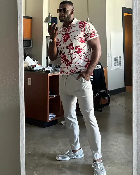 Muscular man in sunglasses and floral shirt posing in a mirror selfie for best black onlyfans.