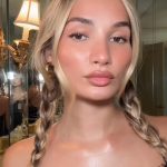 Close-up portrait of Pia Mia with braided blonde hair wearing a black lace top