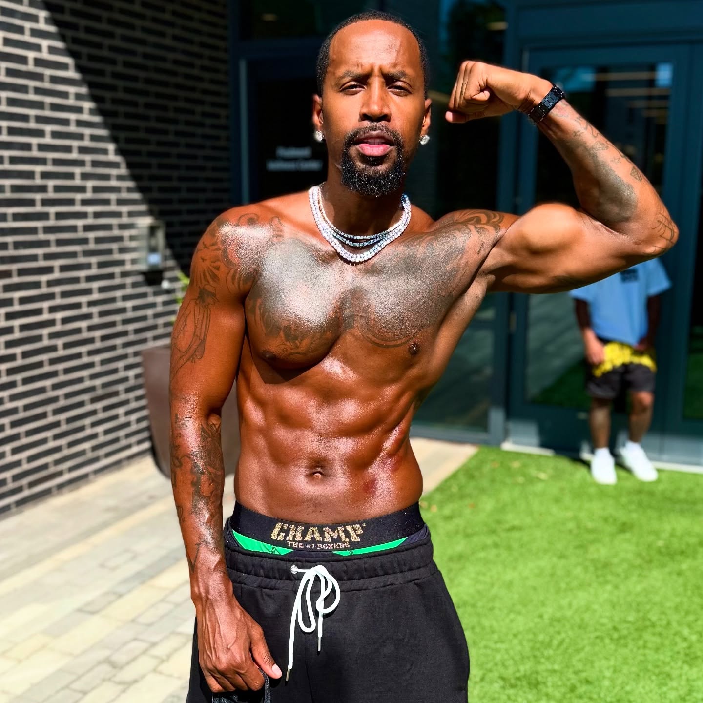 Shirtless muscular creator flexing outside in sunlight