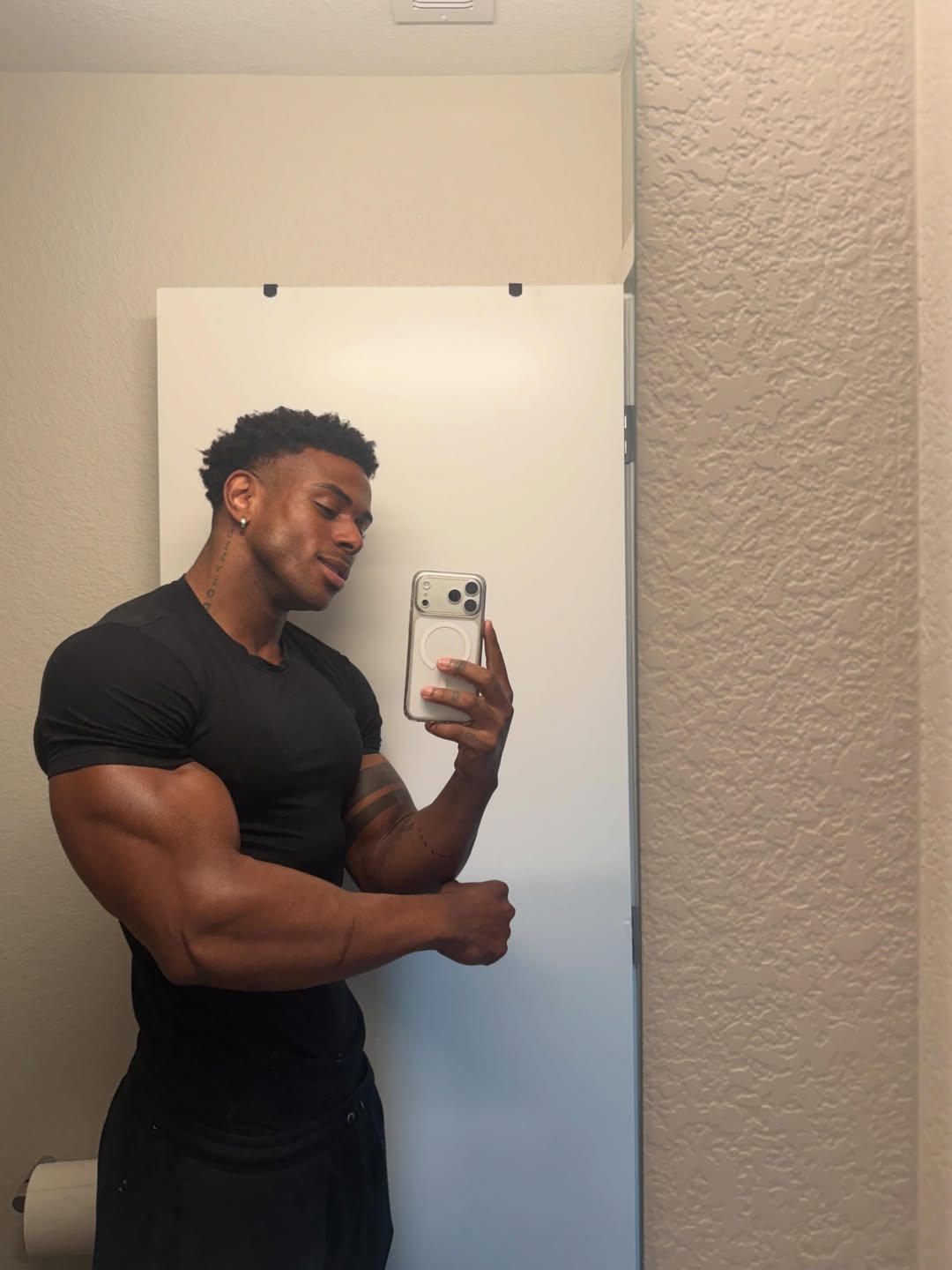 Handsome model taking a mirror selfie flexing his arm muscles, optimized for best black onlyfans keyword.