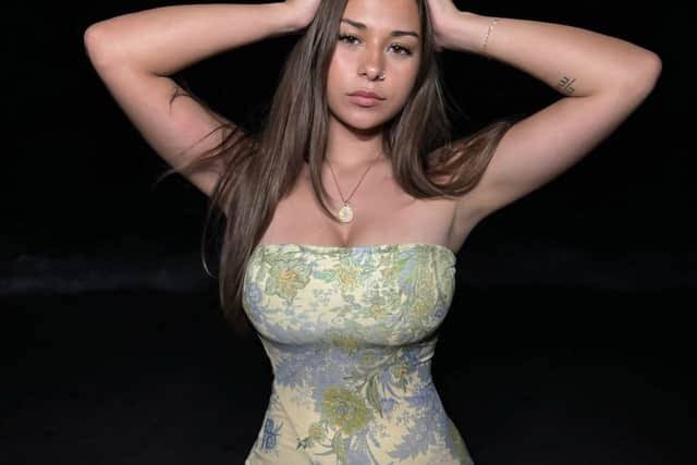 Sophie Rain posing in a floral strapless dress outdoors at night, related to discussions surrounding the sophie rain onlyfans tax.