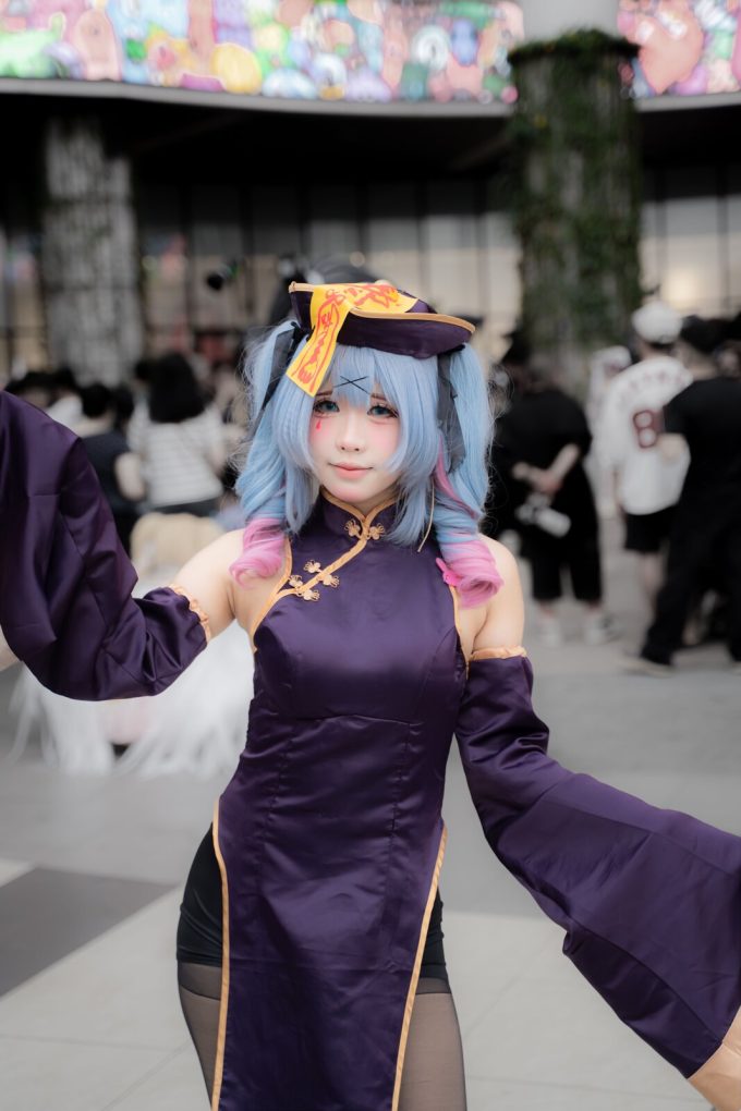 Cosplayer in colorful anime-inspired costume performing at an outdoor convention gathering