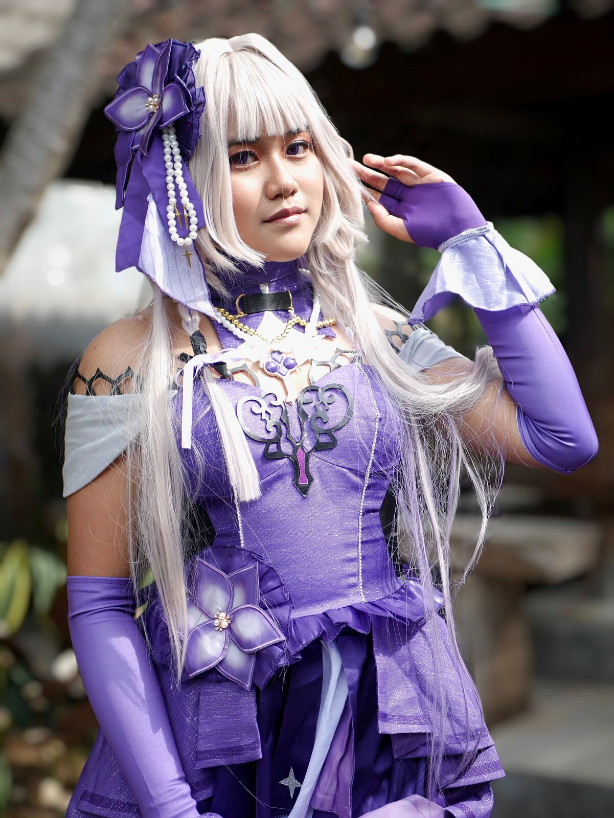 Close-up portrait of a cosplayer in an elaborate purple anime-inspired costume