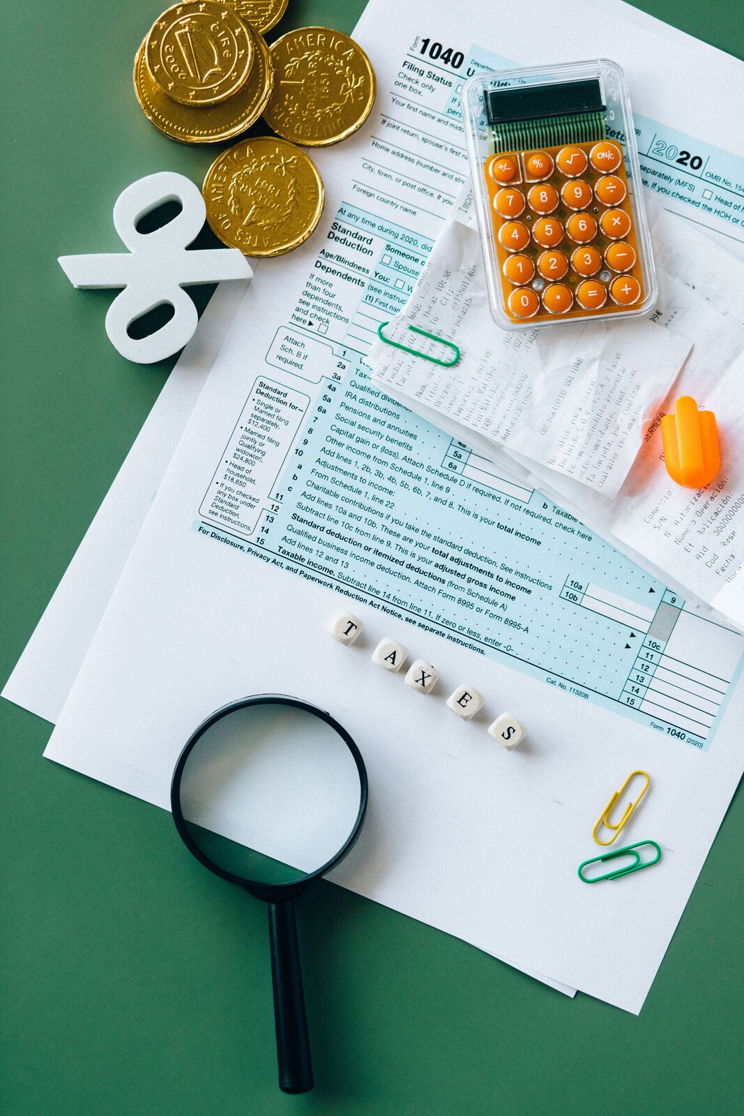 Tax documents, calculator, and coins on a desk representing income tax obligations for OnlyFans creators