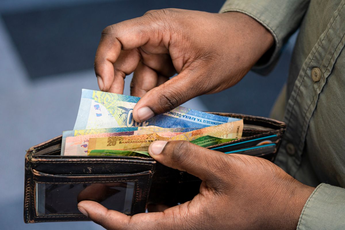Hands counting South African rand banknotes from a wallet, illustrating South Africa OnlyFans earnings