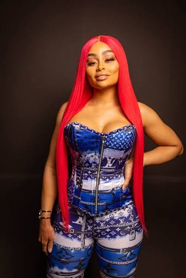 Portrait of model and celebrity Blac Chyna, recognized among the Highest Paid OnlyFans Creators, wearing a vibrant blue designer corset top and long bright red hair.