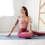 Dani performing a seated stretch on a yoga mat, featured in Yoga OnlyFans creator lists.