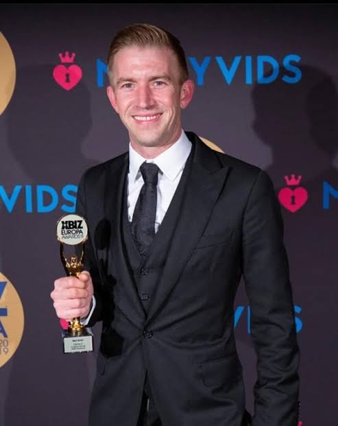 Adult film star Danny D holding an award at an event.