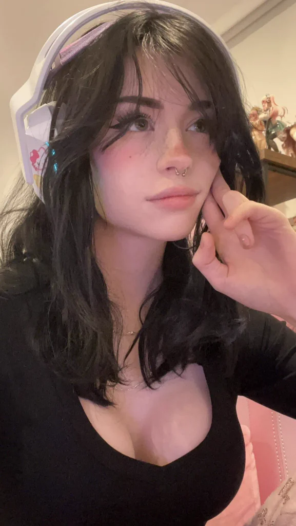 Hannah Owo with black hair and white gaming headset in a black top