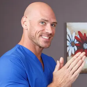 Johnny Sins posing in medical scrubs, mentioned in discussions about YouTubers With OnlyFans.