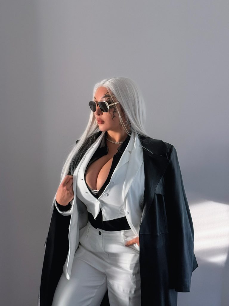 Louisa Khovanski with long white hair, sunglasses, black leather coat over white shirt and pants – twitch streamers with onlyfans