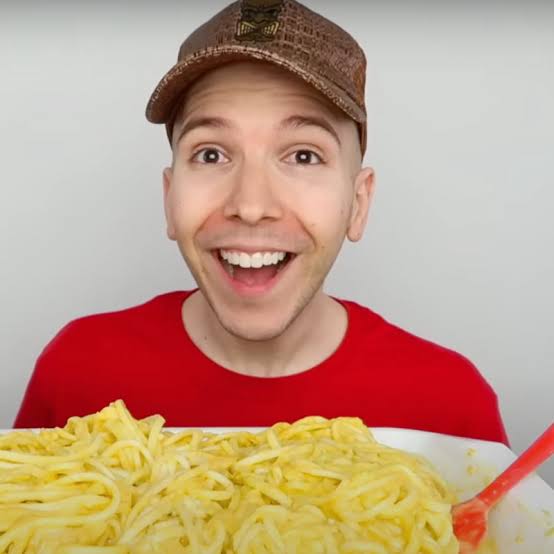 Nikocado Avocado smiling with a plate of food, noted among notable YouTubers With OnlyFans.