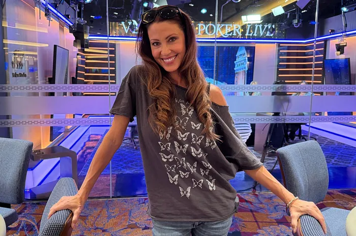 Actress Shannon Elizabeth smiling in a casual grey butterfly t-shirt inside a live broadcast studio